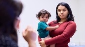 Mother holding child while speaking with clinician