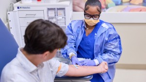 Clinician drawing blood from pediatric patient
