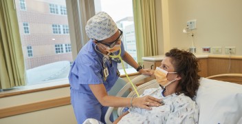 pregnant woman in hospital bed being examined by clinician 