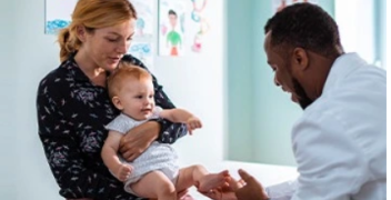 Physician attending to mother and child