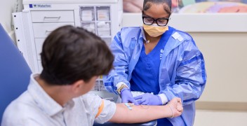 Clinician drawing blood from pediatric patient