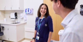 Clinician speaks with adolescent in clinical setting