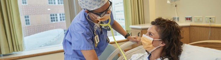 pregnant woman in hospital bed being examined by clinician 