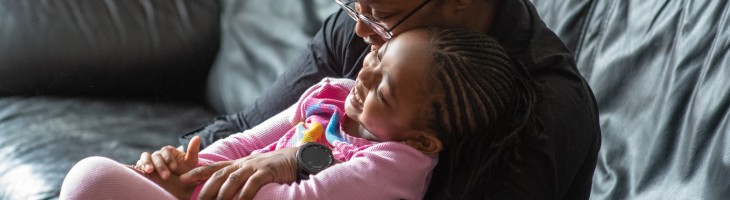 Mother and Daughter embracing on couch, smiling