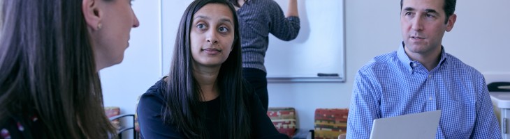 Clinicians around table engaged in work