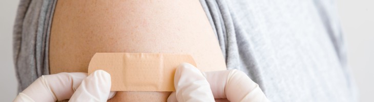 Band aid being affixed to upper arm