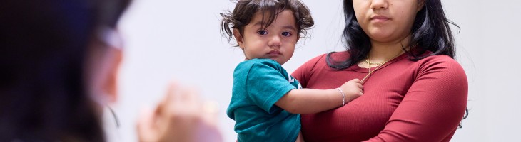 Mother holding child while speaking with clinician