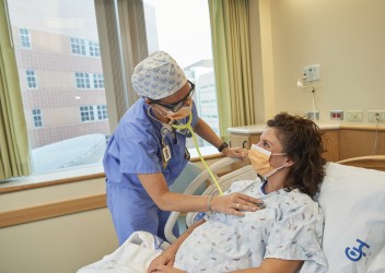 pregnant woman in hospital bed being examined by clinician 