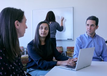 Clinicians around table engaged in work