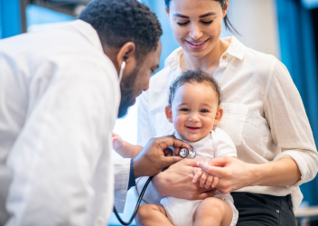 Clinician uses stethoscope to check infant