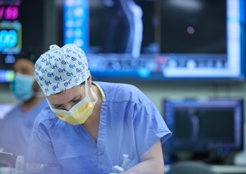 Clinician in operation room with mask and protective equipment on