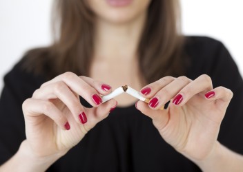 Women breaking cigarette in half