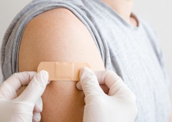 Band aid being affixed to upper arm