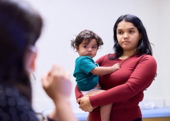 Mother holding child while speaking with clinician