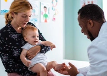 Physician attending to mother and child