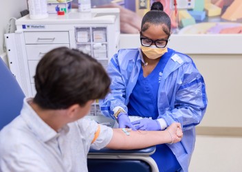 Clinician drawing blood from pediatric patient