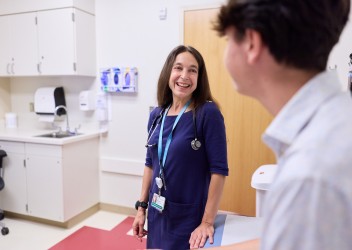 Clinician speaks with adolescent in clinical setting